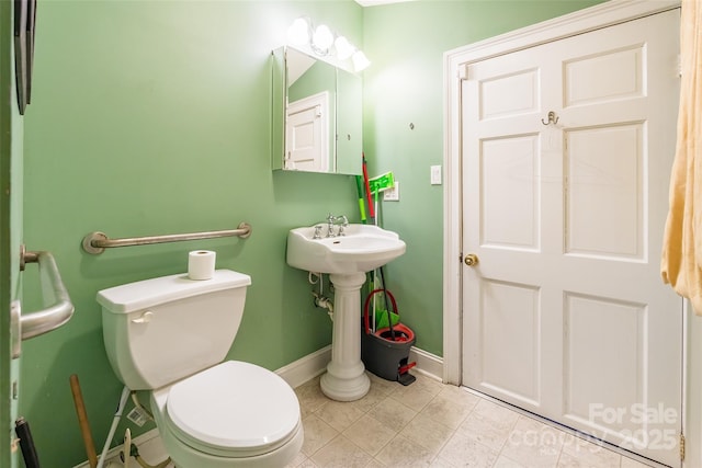 bathroom featuring tile patterned floors, baseboards, and toilet