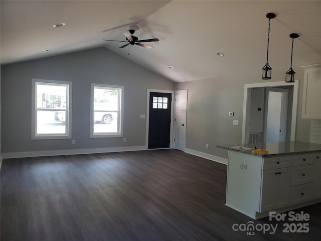 foyer entrance with ceiling fan, baseboards, dark wood finished floors, and vaulted ceiling