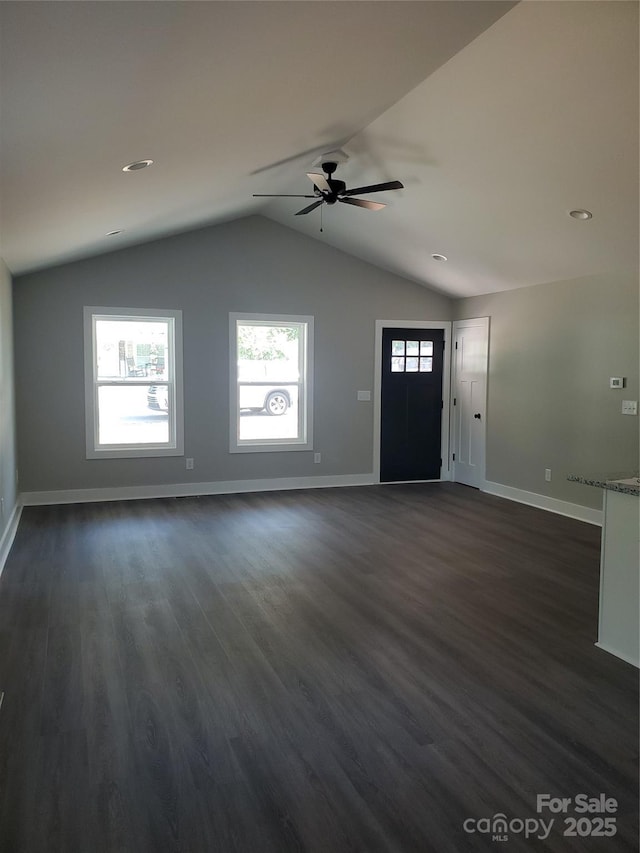 unfurnished living room with dark wood finished floors, ceiling fan, baseboards, and vaulted ceiling