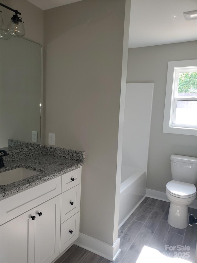 full bath featuring vanity, baseboards, a bathing tub, a shower, and toilet