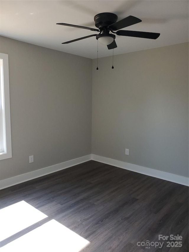 unfurnished room with dark wood-type flooring, baseboards, and ceiling fan