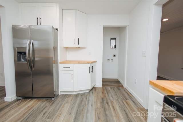 kitchen with light wood-type flooring, butcher block counters, stainless steel refrigerator with ice dispenser, and white cabinets