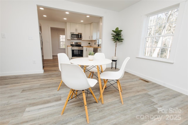 dining space with recessed lighting, baseboards, and light wood finished floors