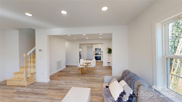 interior space featuring recessed lighting, light wood-type flooring, visible vents, and stairs