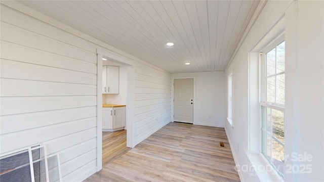 unfurnished room with light wood finished floors, recessed lighting, and wood ceiling