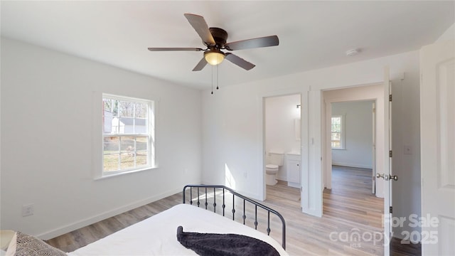 bedroom with light wood finished floors, a ceiling fan, ensuite bathroom, and baseboards