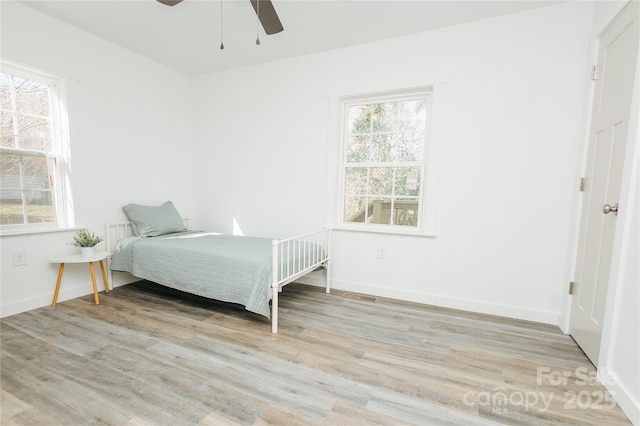 bedroom with ceiling fan, baseboards, and wood finished floors