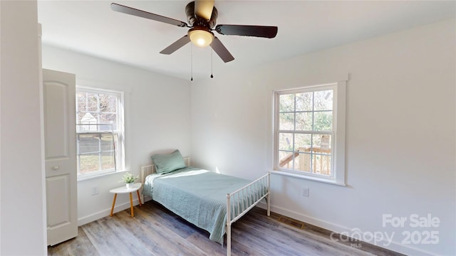 bedroom featuring wood finished floors, baseboards, and ceiling fan