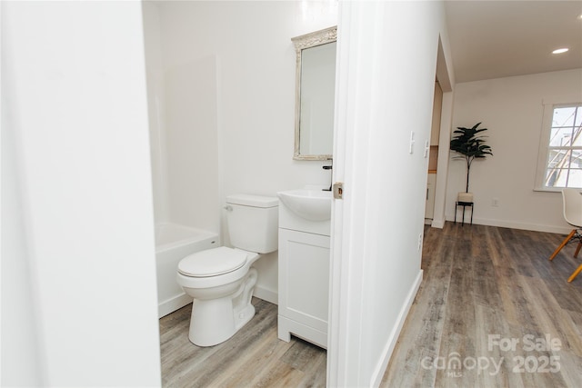 bathroom featuring vanity, toilet, wood finished floors, and baseboards