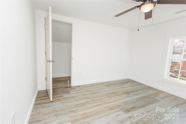 empty room featuring light wood-type flooring, visible vents, baseboards, and ceiling fan