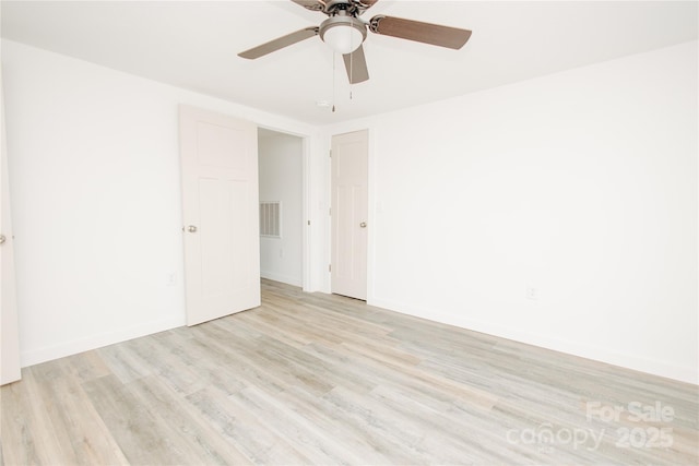 unfurnished room with visible vents, a ceiling fan, light wood-type flooring, and baseboards