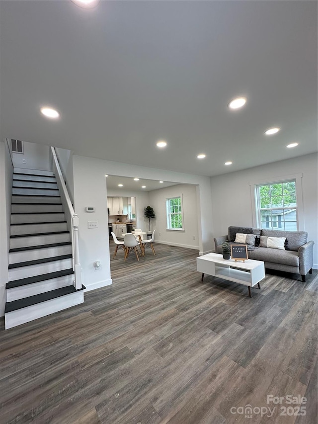 living room featuring recessed lighting, baseboards, stairs, and wood finished floors