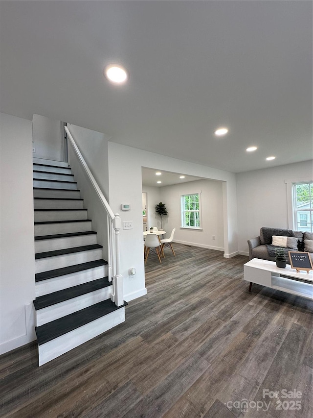 living room featuring recessed lighting, baseboards, dark wood finished floors, and stairway