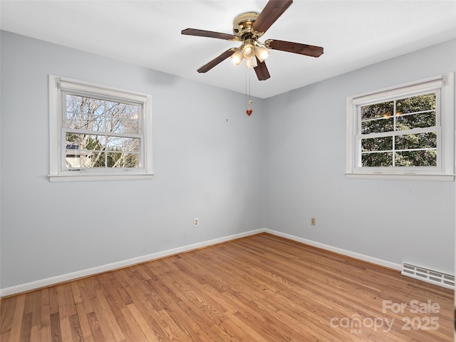 empty room with visible vents, baseboards, light wood-style floors, and a ceiling fan