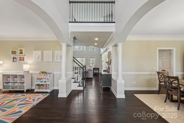 entrance foyer with baseboards, stairs, ornamental molding, wood finished floors, and ornate columns