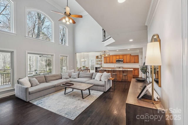 living room with recessed lighting, ceiling fan with notable chandelier, dark wood finished floors, and ornamental molding