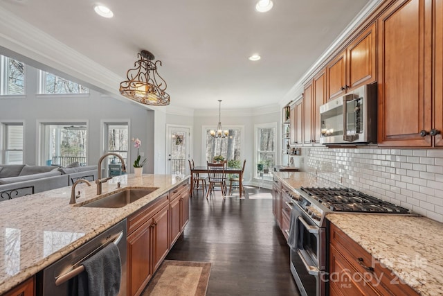 kitchen featuring ornamental molding, a sink, backsplash, stainless steel appliances, and brown cabinetry