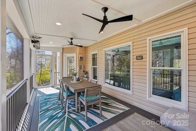 sunroom / solarium with a ceiling fan and wood ceiling