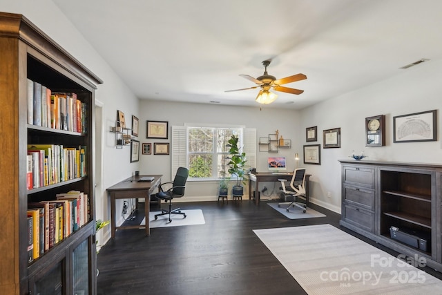 office with dark wood-style floors, visible vents, ceiling fan, and baseboards