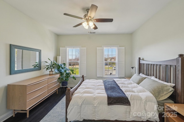 bedroom featuring baseboards, ceiling fan, and dark wood-style flooring