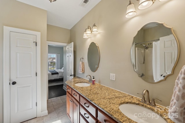 bathroom featuring a sink, visible vents, double vanity, and tile patterned floors