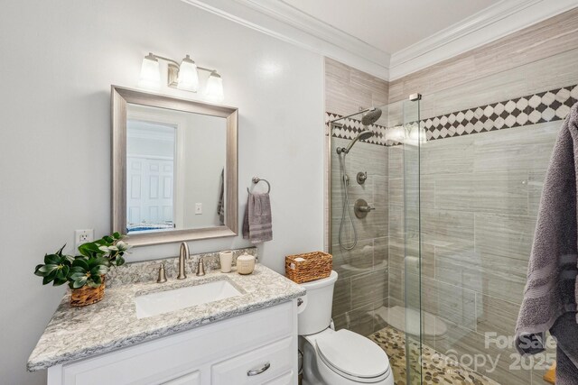 full bath featuring vanity, a stall shower, crown molding, and toilet