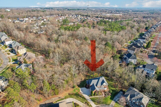 drone / aerial view with a wooded view and a residential view