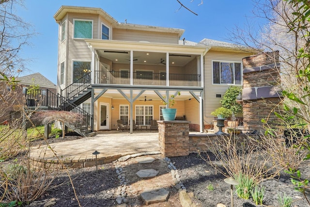 back of property featuring stairway, a sunroom, ceiling fan, and a patio area