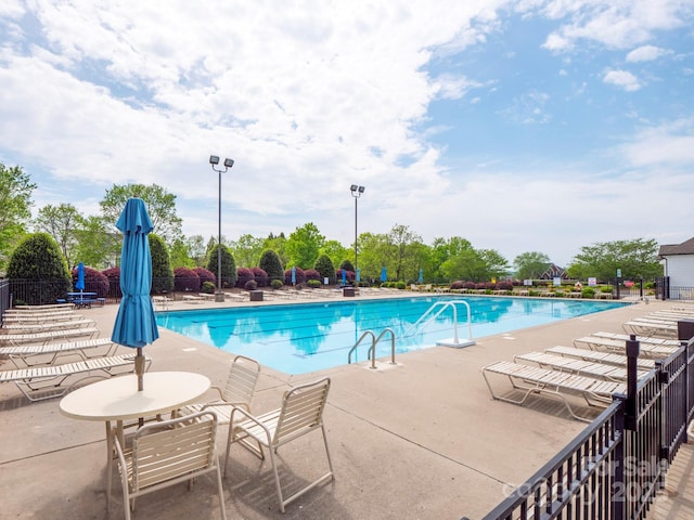 pool with fence and a patio area