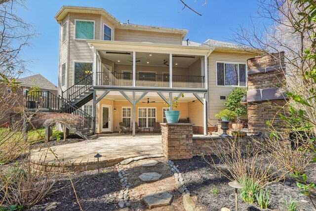 back of house featuring a ceiling fan, a sunroom, a patio, and stairs