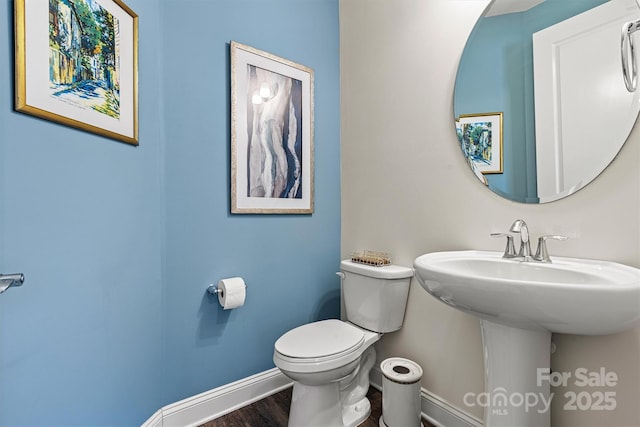 bathroom featuring toilet, baseboards, and wood finished floors