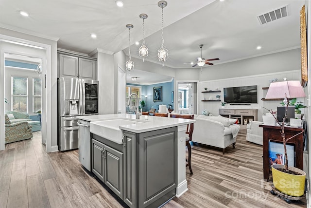 kitchen featuring visible vents, open floor plan, gray cabinets, appliances with stainless steel finishes, and a sink