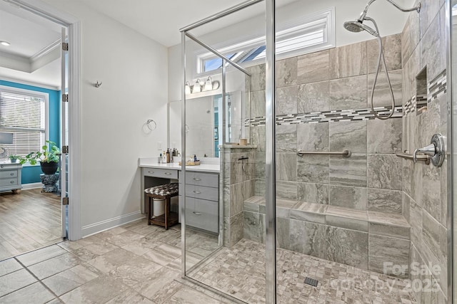 bathroom featuring a shower stall, vanity, crown molding, and baseboards