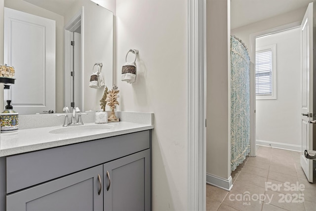 full bathroom with tile patterned flooring, vanity, and baseboards