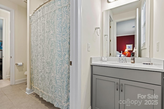 bathroom with tile patterned flooring, baseboards, toilet, ensuite bathroom, and vanity