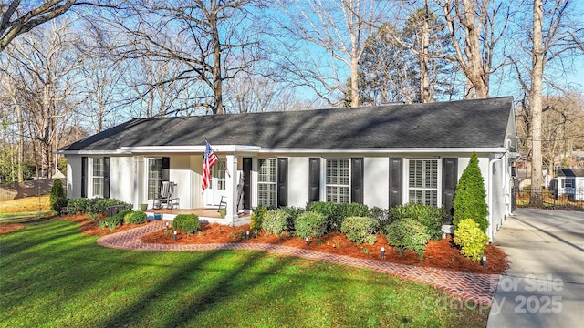 ranch-style home featuring a front lawn and fence