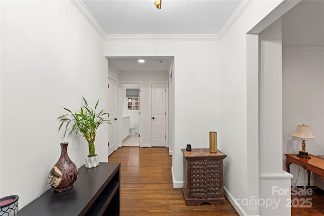 corridor featuring baseboards, wood finished floors, and ornamental molding