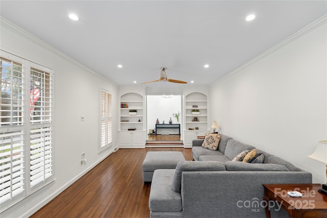 living area with recessed lighting, built in shelves, crown molding, and dark wood-style flooring