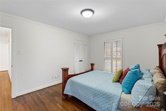 bedroom with baseboards, attic access, wood finished floors, and ornamental molding