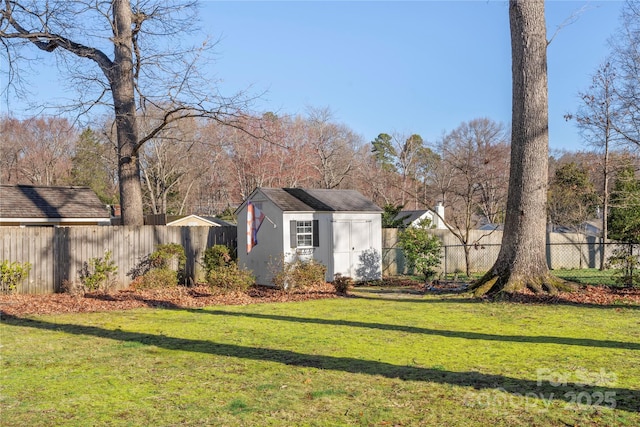 view of yard featuring an outdoor structure, fence, and a shed