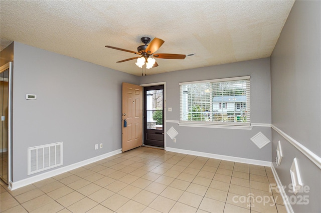 foyer with light tile patterned floors, a ceiling fan, visible vents, and baseboards