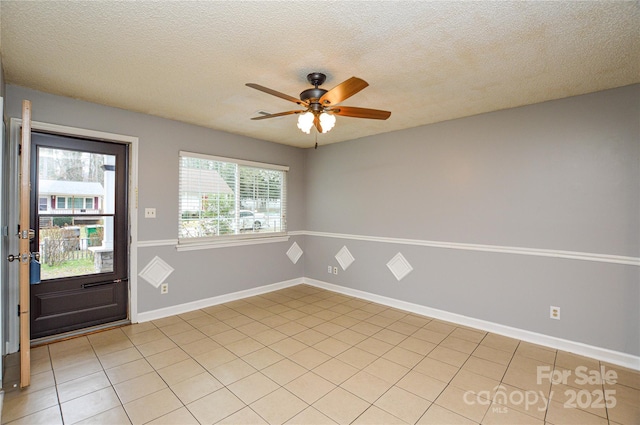 foyer with baseboards, a textured ceiling, ceiling fan, and light tile patterned flooring