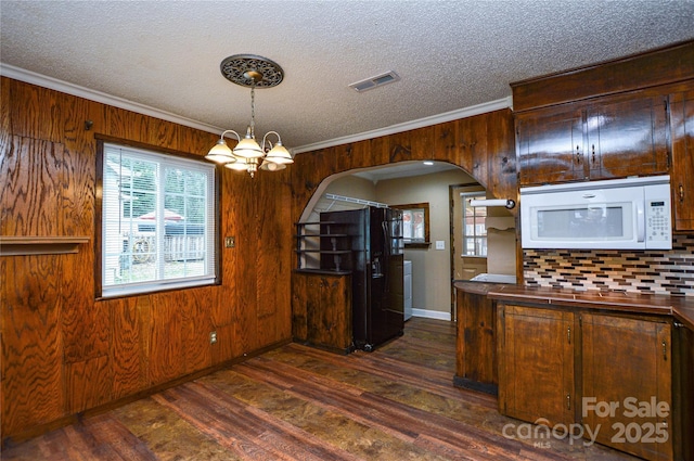 kitchen with white microwave, visible vents, crown molding, dark wood-style floors, and arched walkways