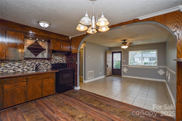 kitchen with visible vents, under cabinet range hood, arched walkways, black / electric stove, and a sink