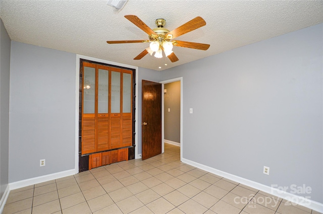 spare room featuring baseboards and a textured ceiling