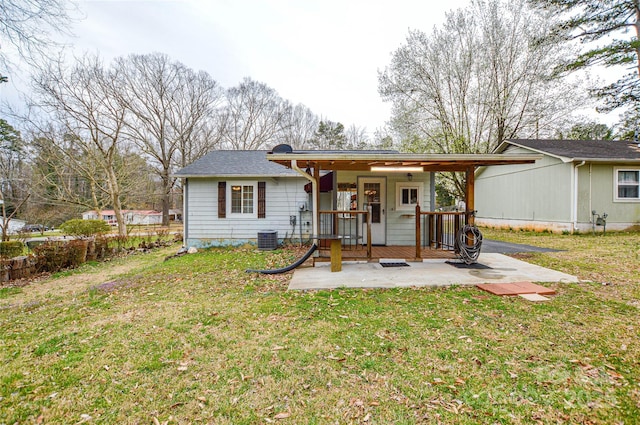 back of house featuring a yard, central AC unit, and a patio