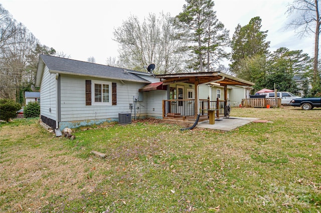 rear view of house with a lawn, central AC unit, and a deck