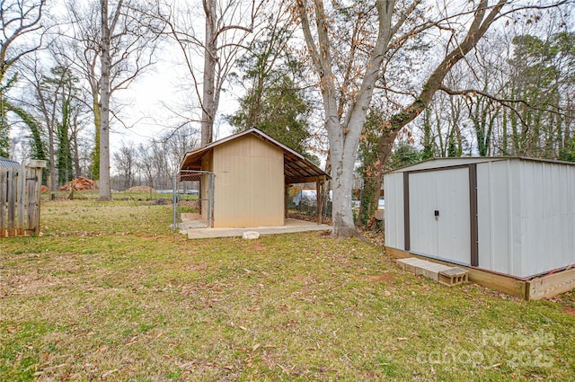 view of yard featuring an outbuilding, fence, and a shed