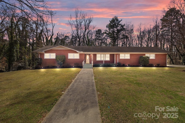 view of front of property with a front lawn and brick siding