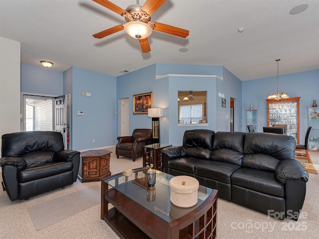 living area featuring visible vents, baseboards, ceiling fan, a textured ceiling, and light colored carpet